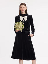 a lady in black jacket with bow and black midi velvet skirt